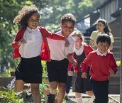 A group of school children running in the school yard as they head to playtime. Two of the children are siblings and go to the same school in Hexham in the North East of England.