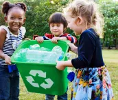 Group of school kids holding a green recycling bucket volunteer charity environment